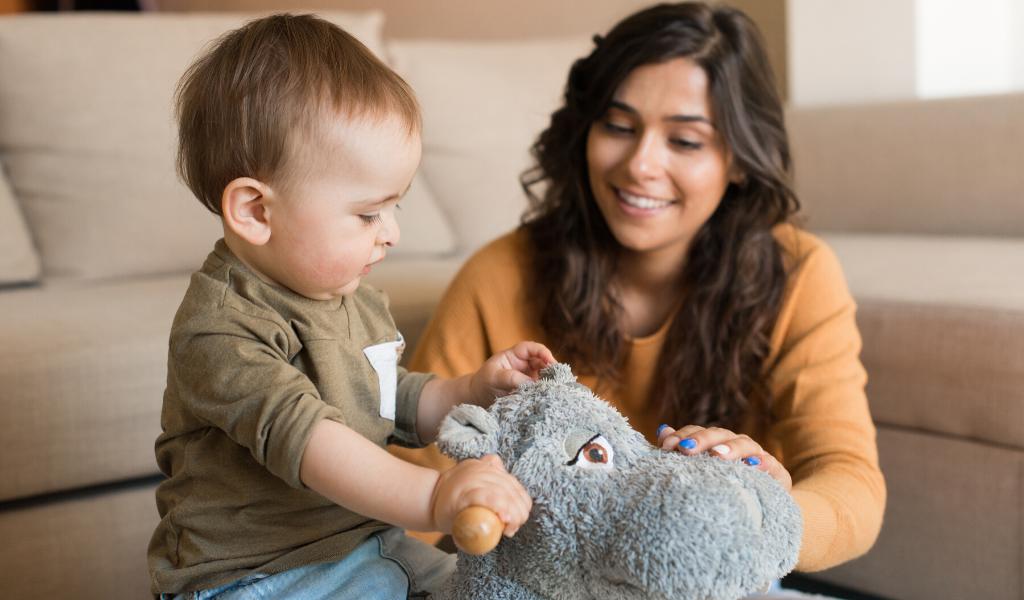 woman playing with baby and toy