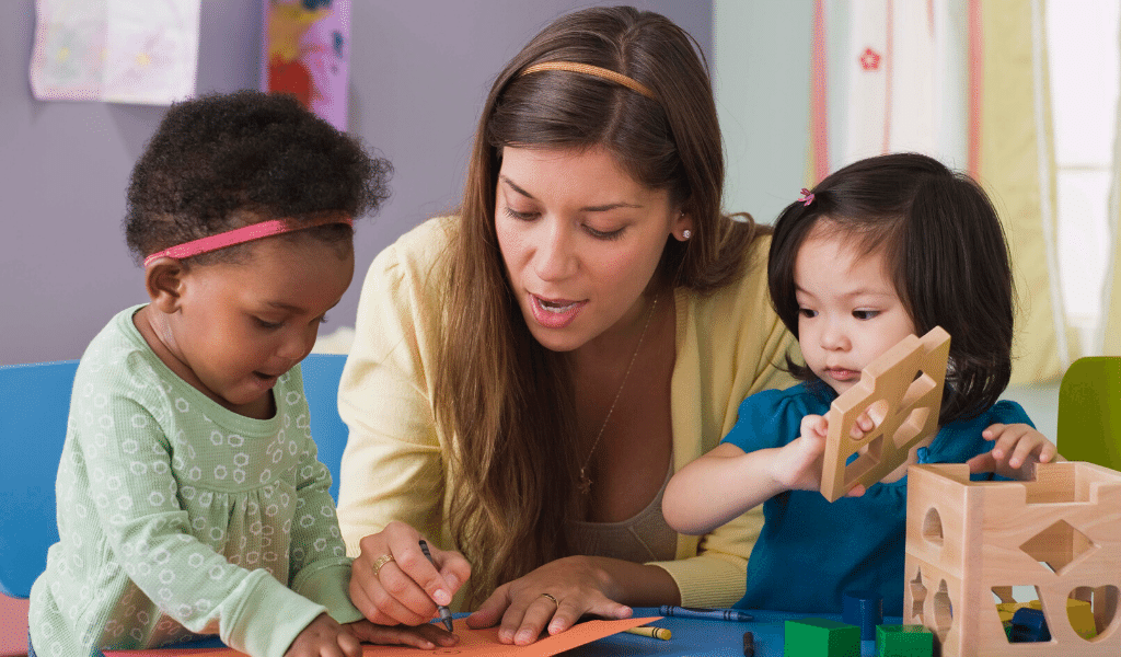 childcare professional with two children at work
