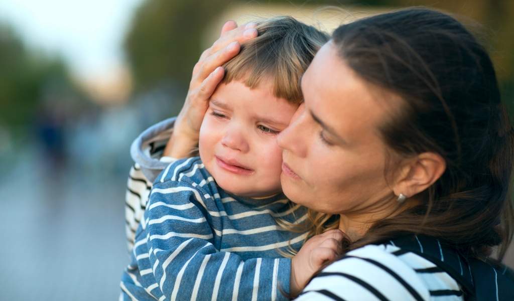 woman holding baby crying