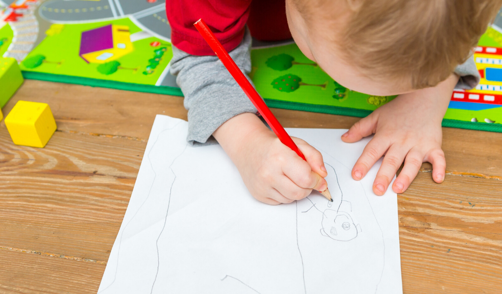 child drawing on paper