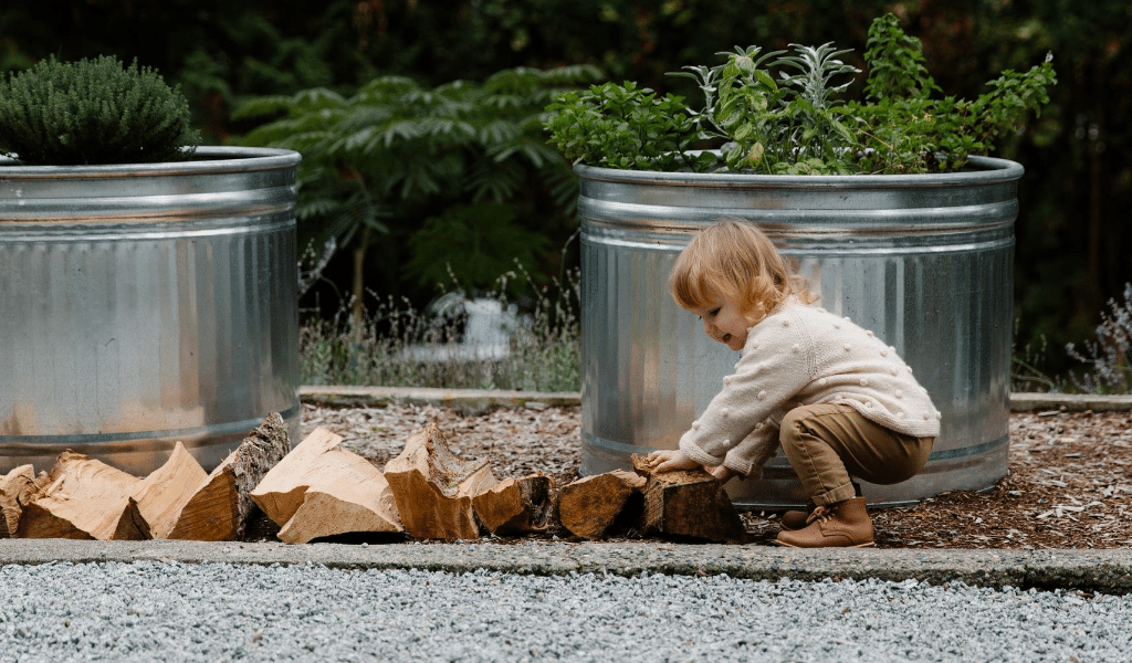 child trying to pick up some logs