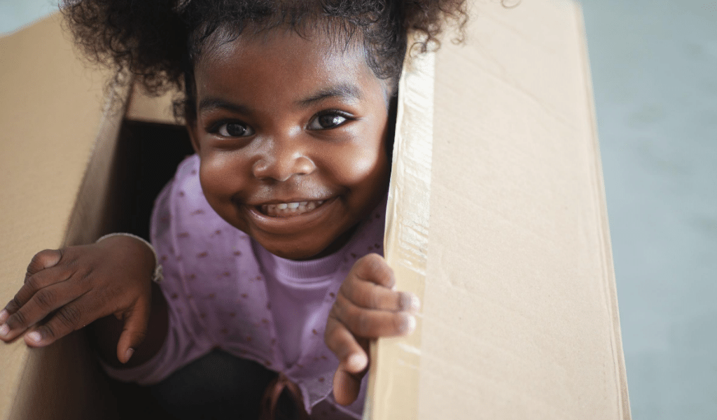 girl coming out a cardboard box