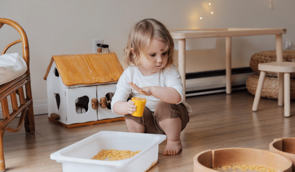 little girl playing with pasta and boxes