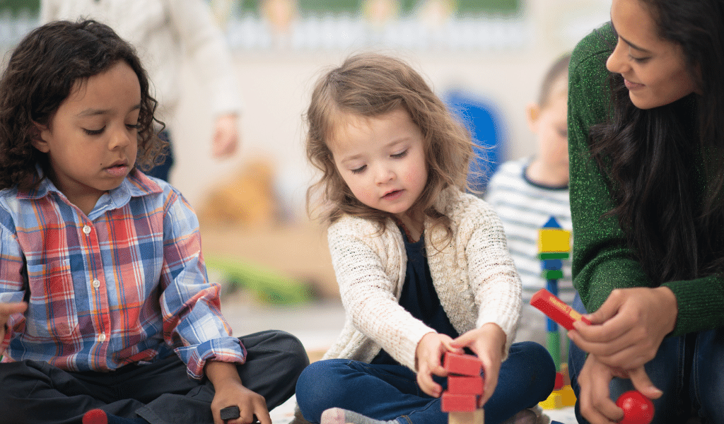 children playing while being observed by an adult