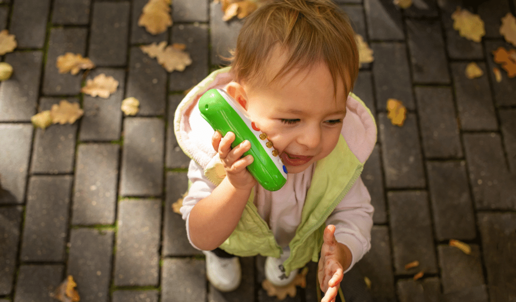 toddler playing with a fake telephone