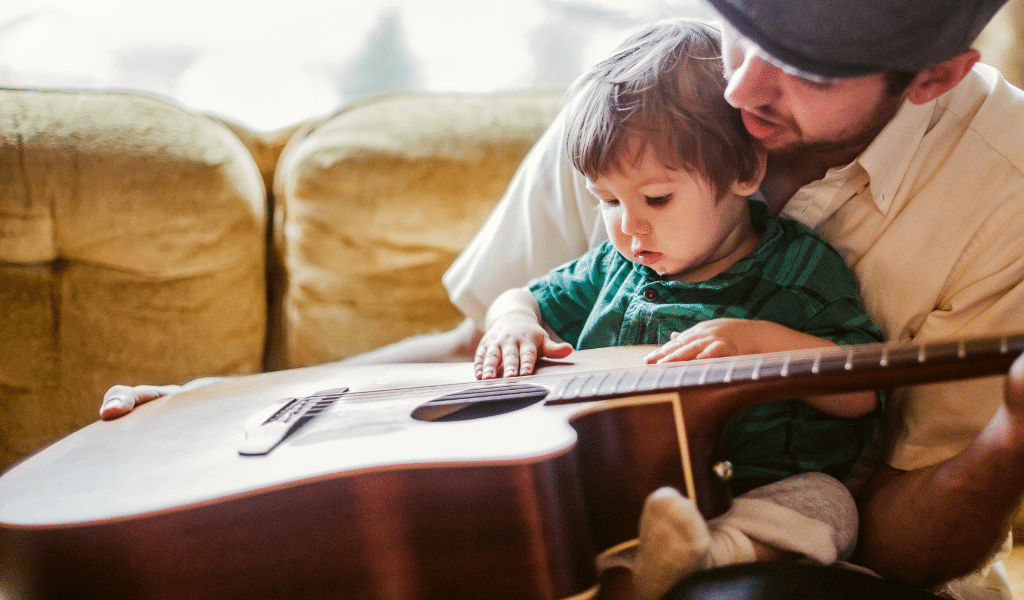 baby listening to dad play guitar