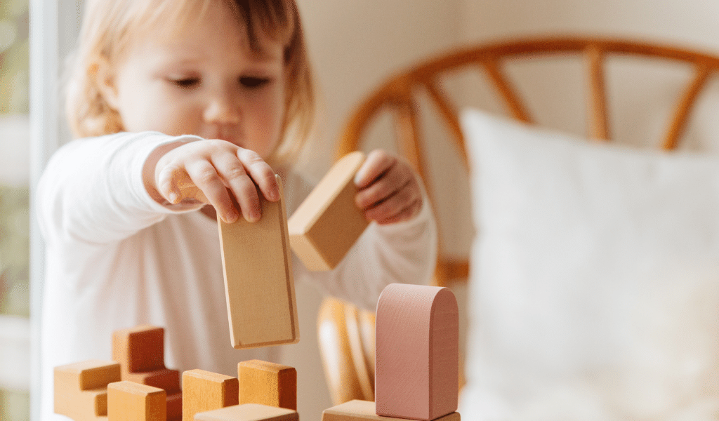 toddler playing with wood blocks