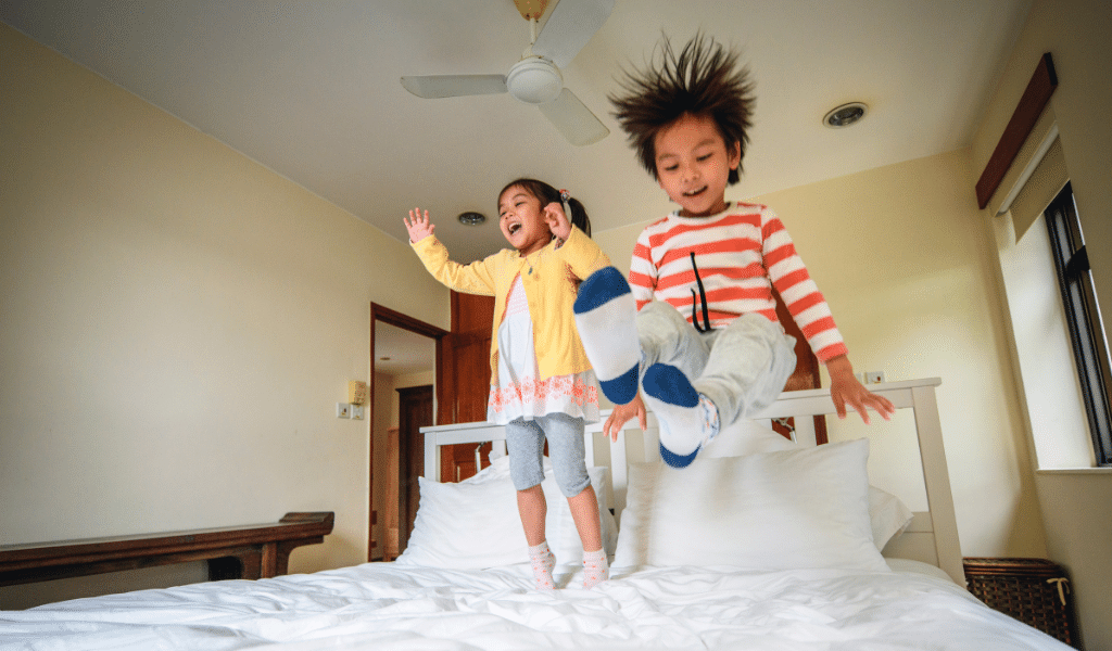 children jumping in bed