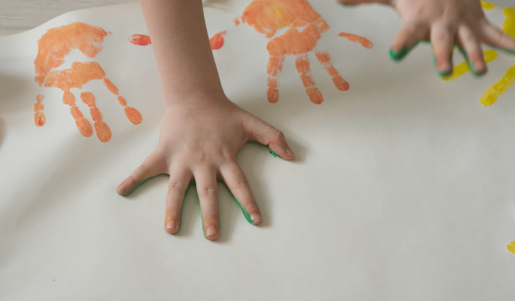 toddler making marks with paint in their hands