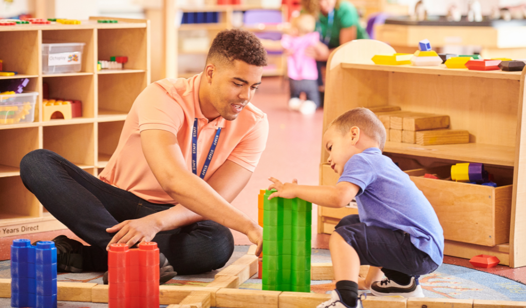 Male nursery worker playing with boy