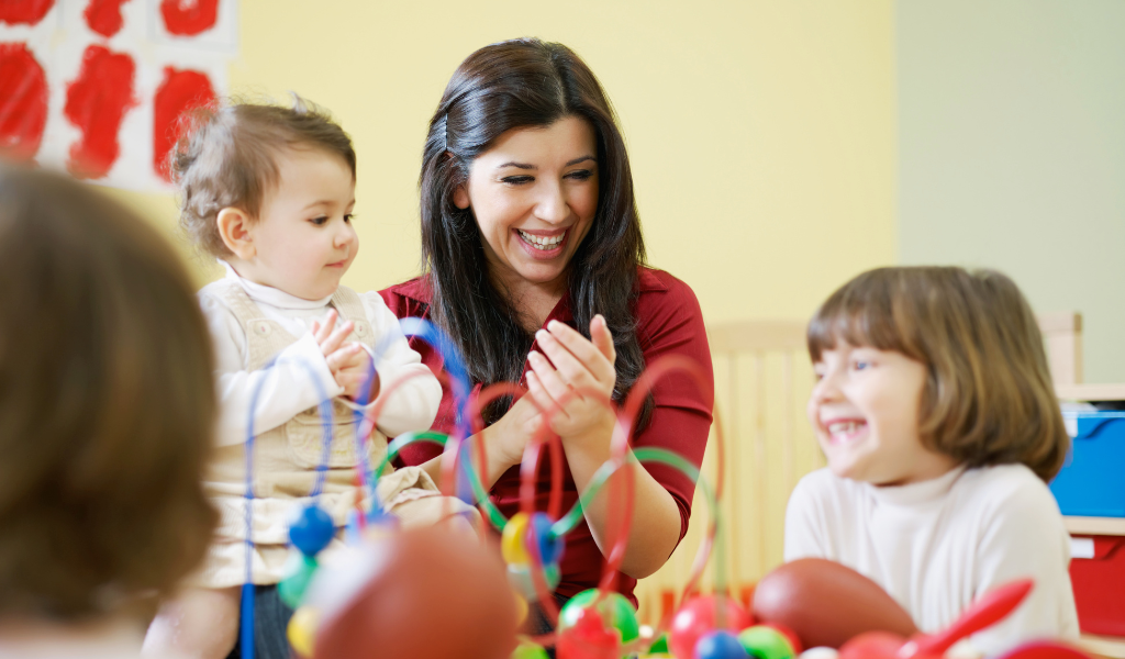 childcare practitioner playing with 2 children 