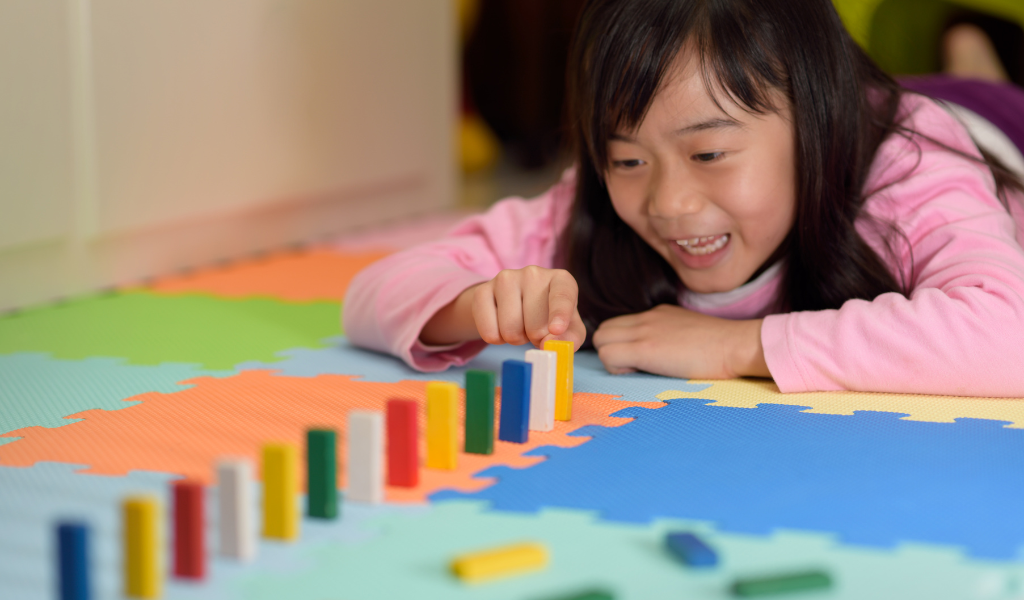Child with coloured blocks in a row