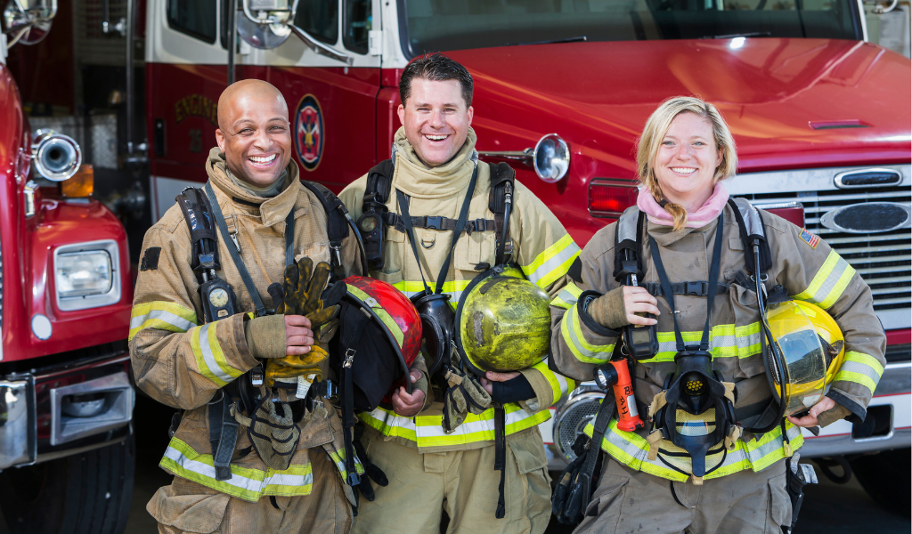 Fire fighters smiling in front of engine