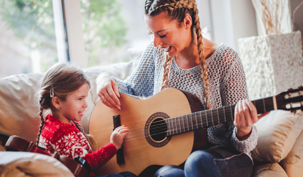 woman playing guitar to a child