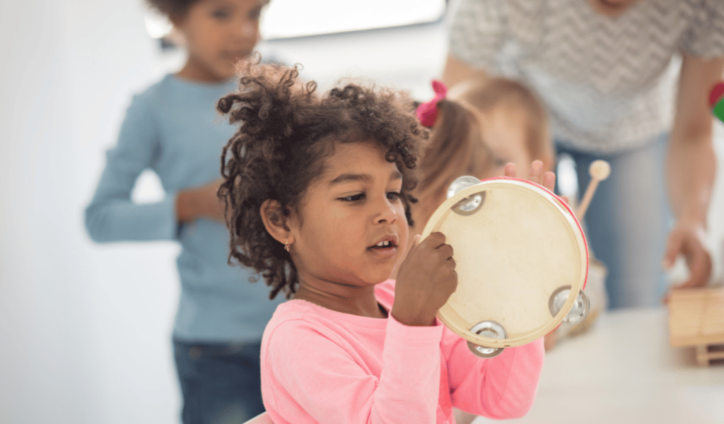 child music playing tambourine