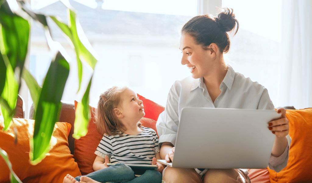 childminder with laptop and children