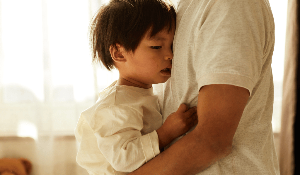 sleepy child being held by parent