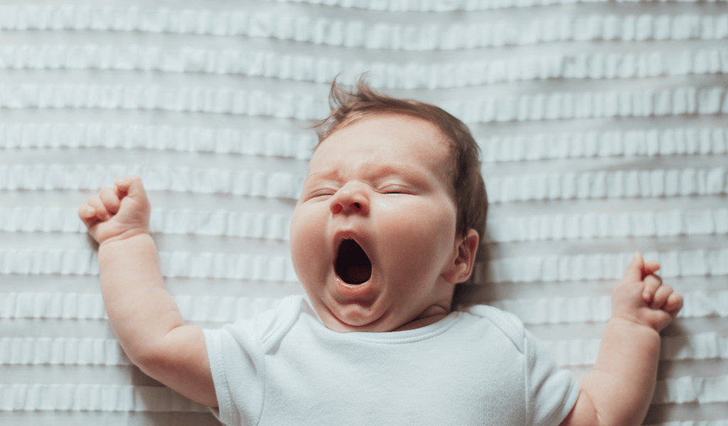 sleepy baby in nursery bed